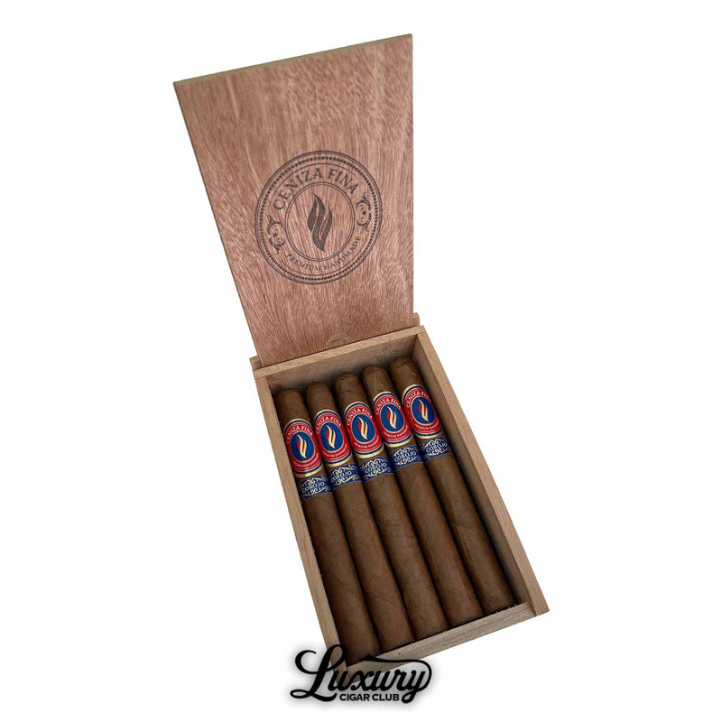 Open wooden cigar box displaying five Ceniza Fina Corojo Corona cigars with red and blue bands, lid engraved with Ceniza Fina logo, Luxury Cigar Club branding below.