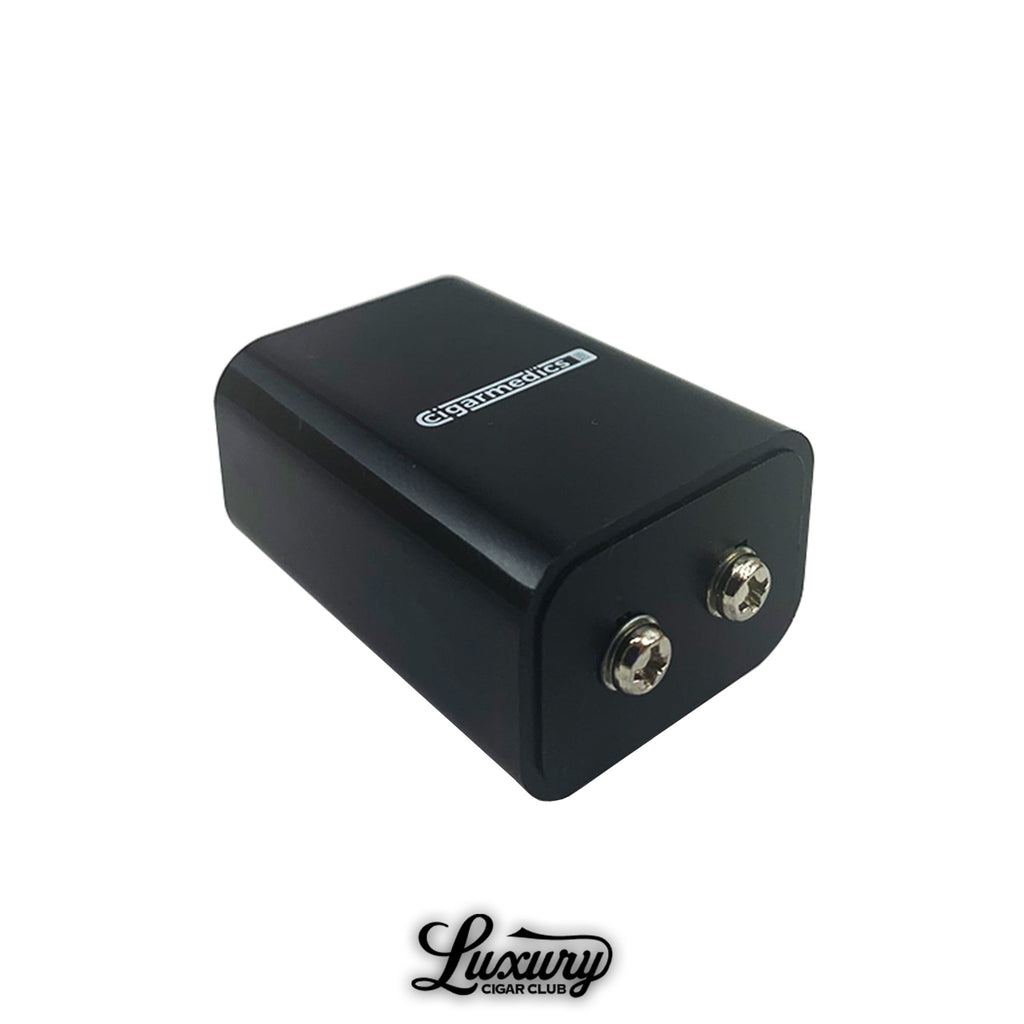 Cigar Medics HumidiMeter calibration tool in black with dual metal connectors, used for accurate cigar humidity testing, displayed on white background with Luxury Cigar Club logo.