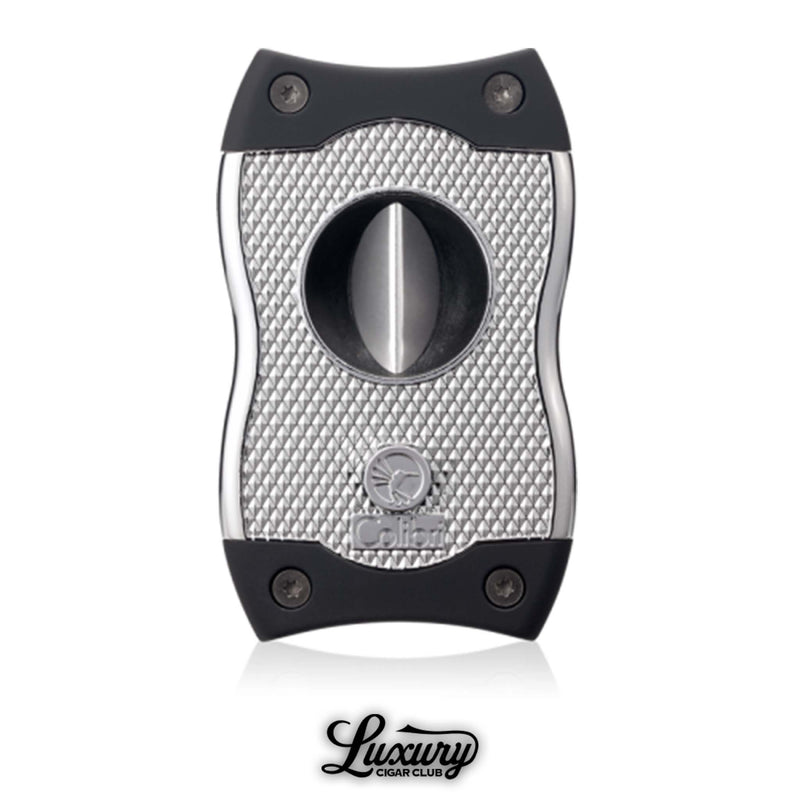 Closed Colibri SV cigar cutter in chrome with textured grip design and dual cutting blades, photographed with Luxury Cigar Club branding.