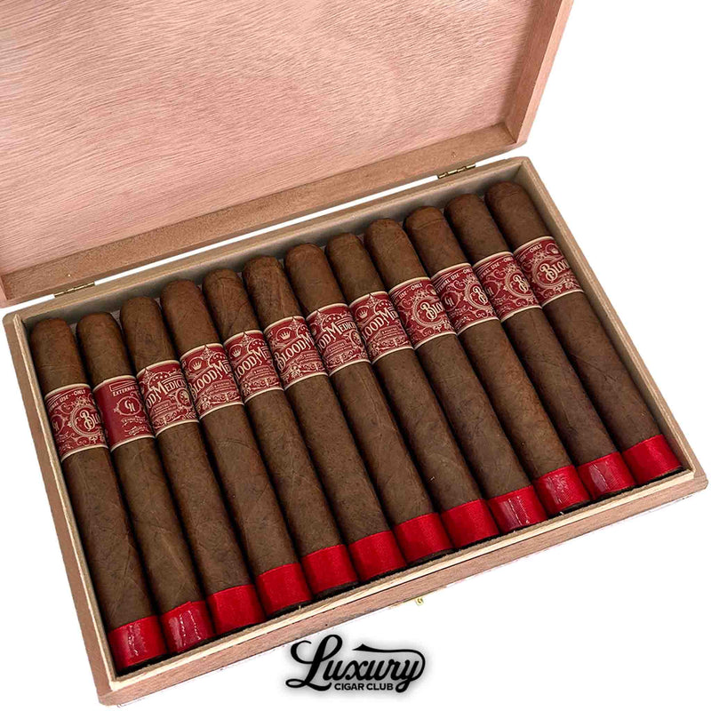 Close up of Crowned Heads Blood Medicine B Positive Limited Edition Toro cigars with red foot bands inside open box at Luxury Cigar Club