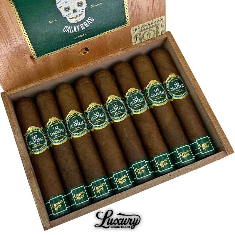Close-up of Crowned Heads Las Calaveras 2025 Limited Edition cigars neatly arranged in an open wooden box, with detailed green and gold bands, presented by Luxury Cigar Club.