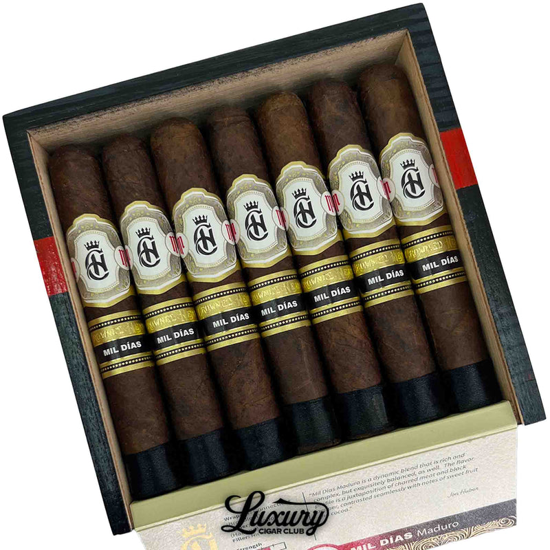 Close-up of Crowned Heads Mil Días Maduro Edmundo cigars in a box with rich dark wrappers and elegant bands, Luxury Cigar Club.
