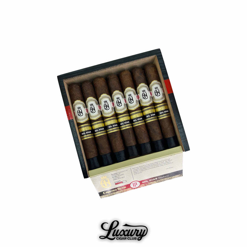 Box of Crowned Heads Mil Días Maduro Edmundo cigars with dark wrappers and black gold bands, Luxury Cigar Club.