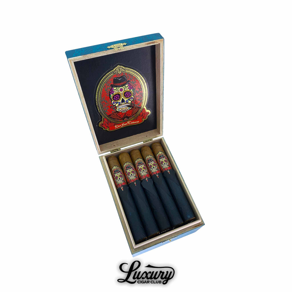 Open blue and wooden box of Danli Honduras Don Juan Calaveras Connecticut Toro cigars featuring vibrant skull artwork on the lid and gold-detailed cigar bands wrapped in black paper sleeves. Luxury Cigar Club logo below.