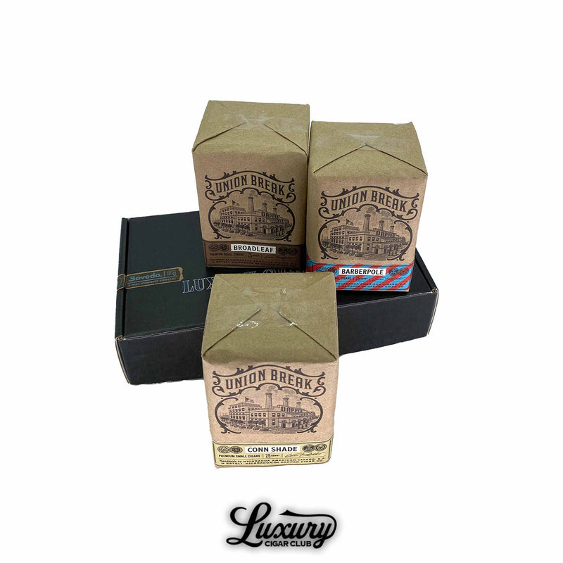 Three packs of Dapper Union Break Petite Lancero cigars featuring Broadleaf Barberpole and Connecticut Shade varieties displayed on a black Luxury Cigar Club box Each pack has vintage style brown paper packaging with factory artwork and blend labels