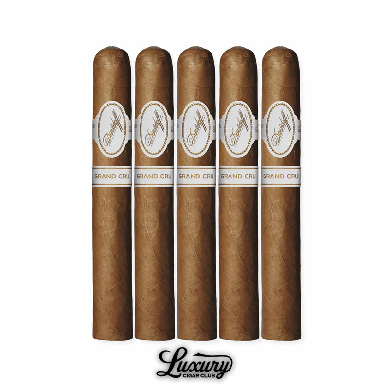 Five Davidoff Grand Cru No. 3 cigars aligned upright, medium-brown wrapper, white Davidoff band with gold accents reading “Grand Cru,” positioned with Luxury Cigar Club logo below.
