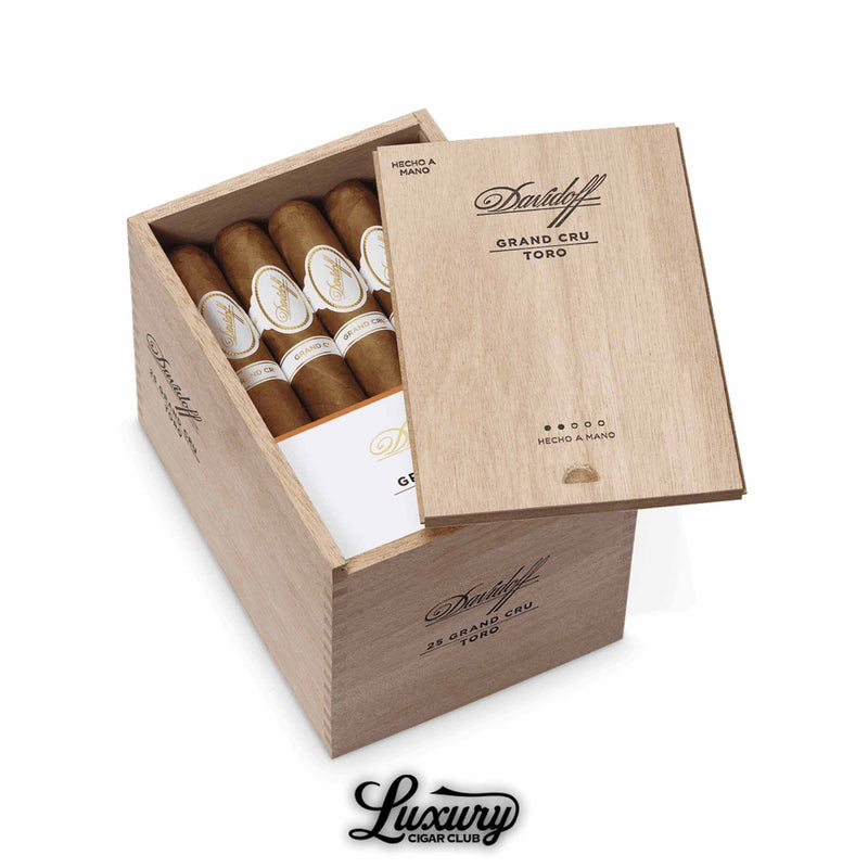 Open wooden Davidoff Grand Cru Toro box of 25 cigars, lid engraved with branding, showing rows of hand-rolled cigars inside, displayed with the Luxury Cigar Club logo.