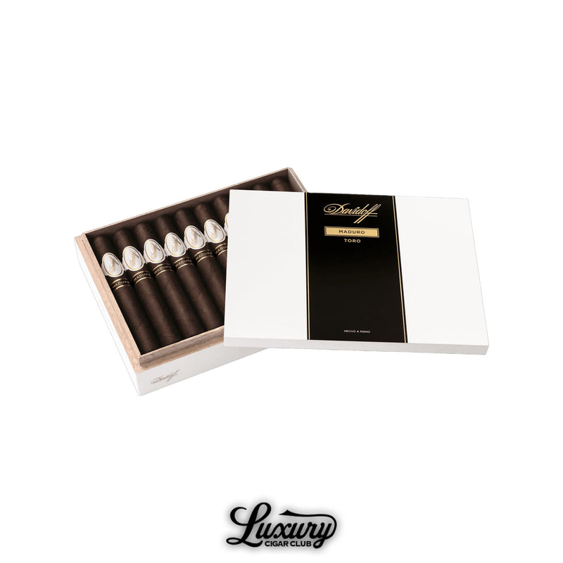 Open Davidoff cigar box with white exterior and black gold-accented label reading Maduro Toro, filled with dark brown cigars, Luxury Cigar Club branding