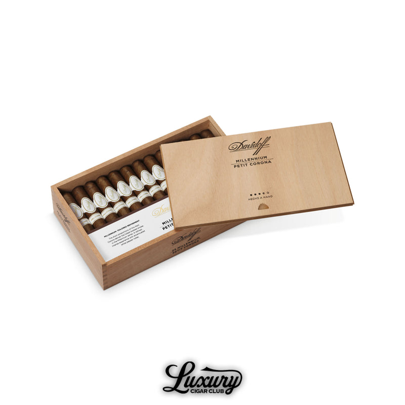 Image of Davidoff Millennium Petit Corona cigars arranged in a cedar box with a partially opened lid, showcasing white banded cigars.