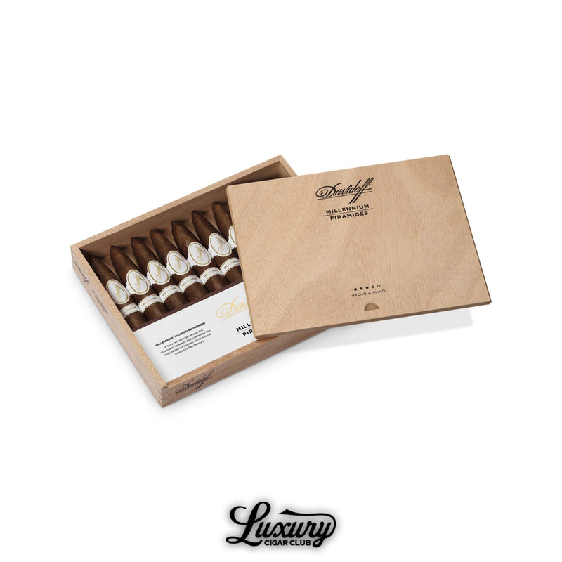 A wooden box of Davidoff Millennium Piramides cigars featuring pointed heads and clean white bands, under a light wood cover.