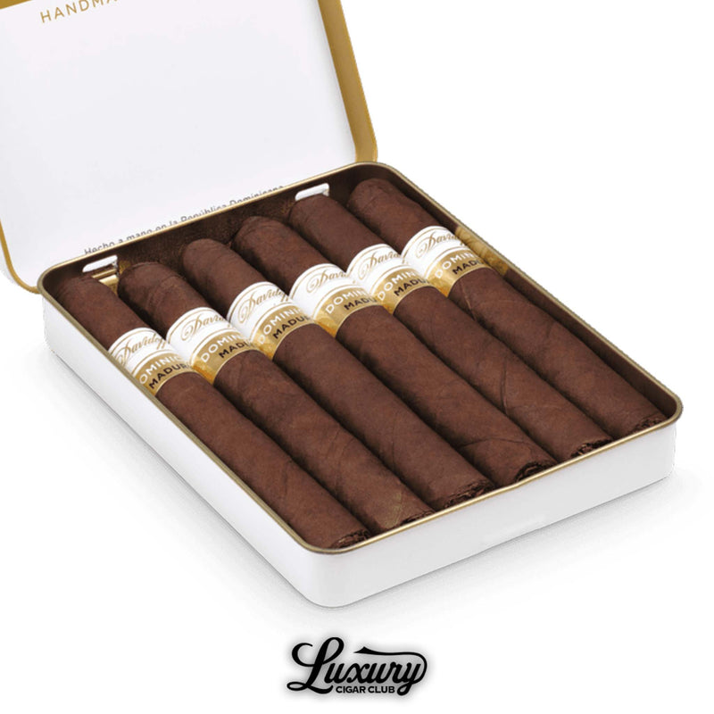 Close-up view of Davidoff Primeros Dominican Maduro Petit Panatela cigars in a white tin, showcasing dark brown wrappers and elegant white and gold bands, with the Luxury Cigar Club logo beneath.