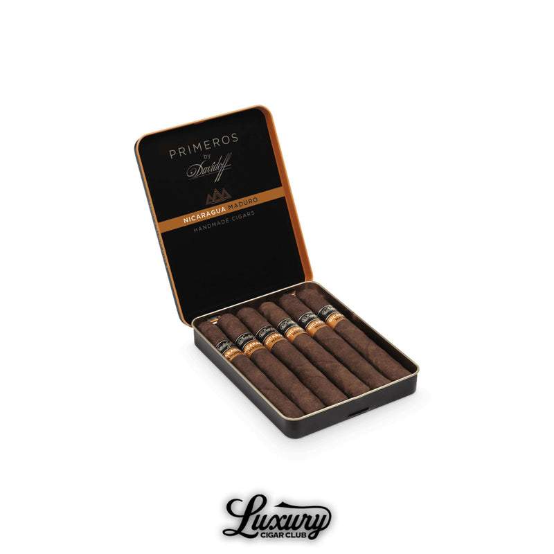 Open tin of Davidoff Primeros Nicaragua Maduro Petit Panatela cigars, featuring dark brown wrappers and black bands with orange accents, set against a white background with Luxury Cigar Club branding.
