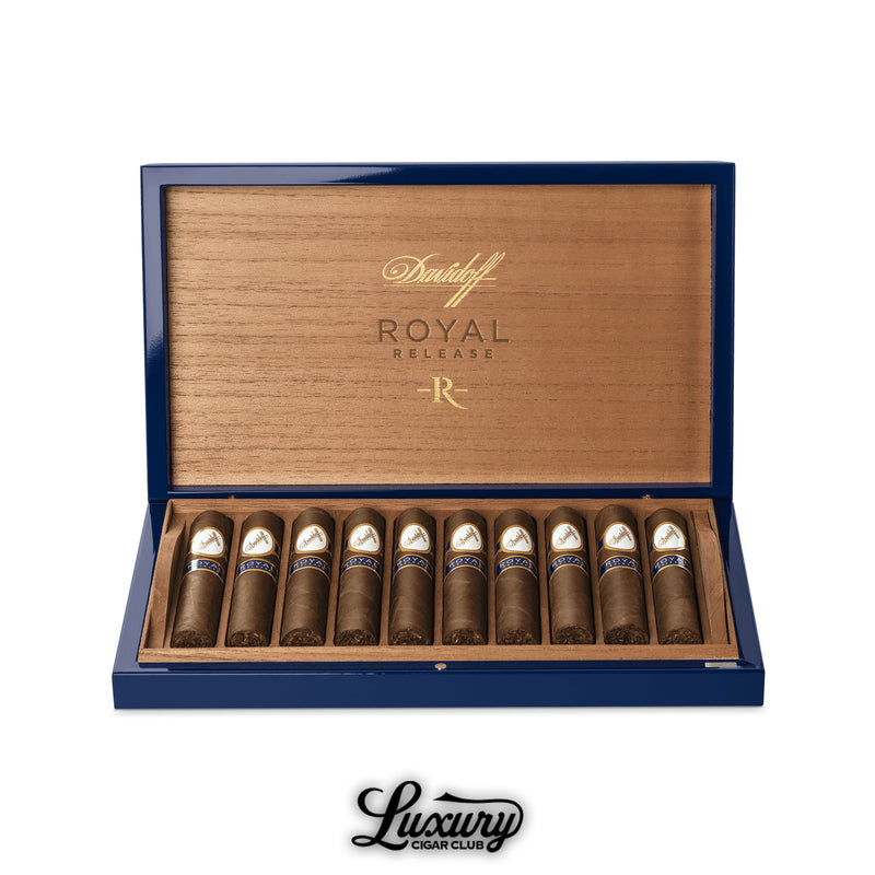Open wooden and blue Davidoff Royal Release box containing ten Robusto cigars arranged in rows, featuring white-and-gold primary bands with blue “Royal Release” secondary labels, Luxury Cigar Club logo beneath.