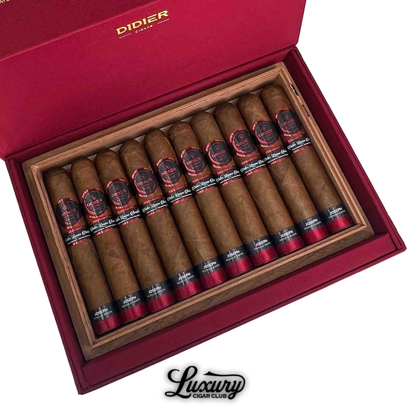 Close-up of Didier Joseph cigars in a red box, showing detailed black and red cigar bands and natural brown wrappers inside a cedar tray.