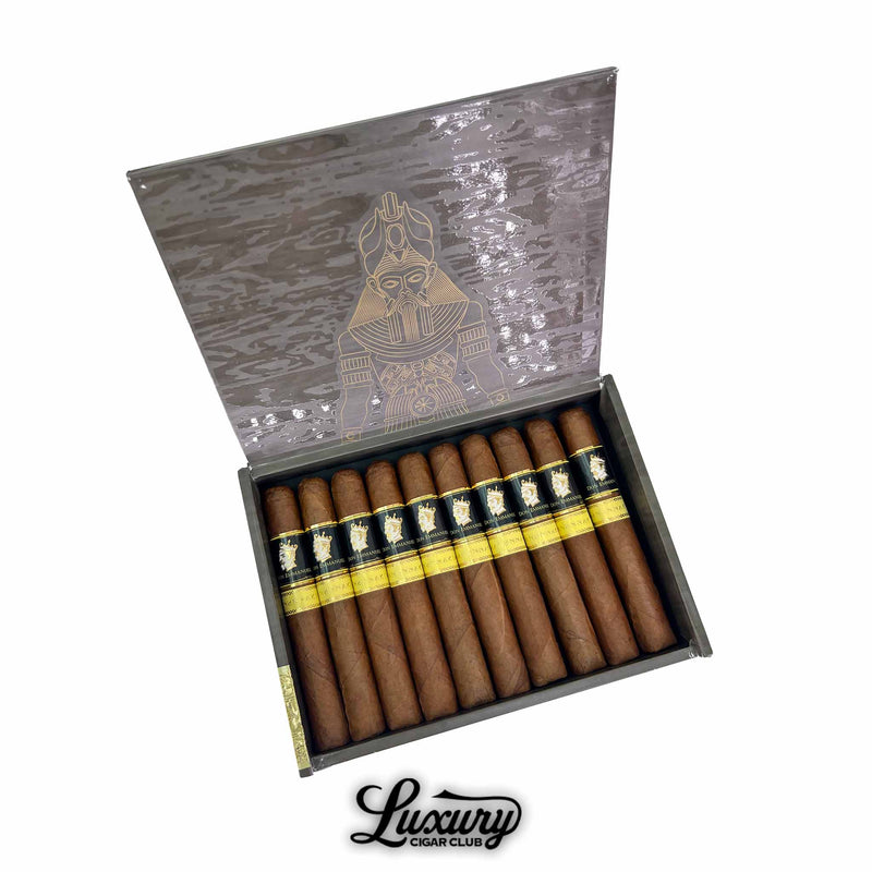 Open box of Don Emmanuel Anunnaki Anu cigars with ornate gold design on the lid, displaying neatly arranged cigars with black and gold bands, photographed for Luxury Cigar Club.