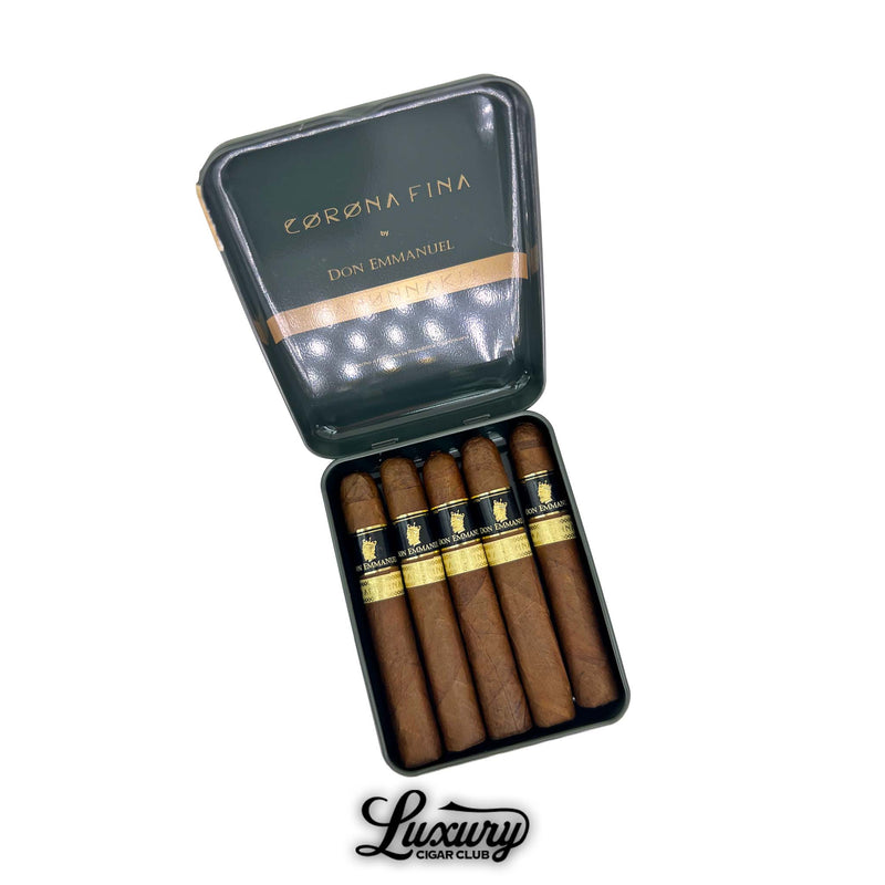 Open metal tin of Don Emmanuel Anunnaki Corona Fina cigars, with five slim cigars inside, bands featuring gold crown details, photographed for Luxury Cigar Club.