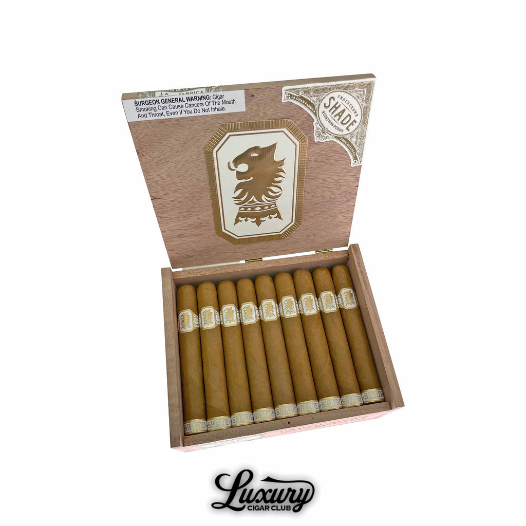 Drew Estate Undercrown Shade Gran Toro cigars displayed in an open wooden box, showcasing smooth golden Connecticut Shade wrappers and the signature crowned lion band, presented by Luxury Cigar Club.