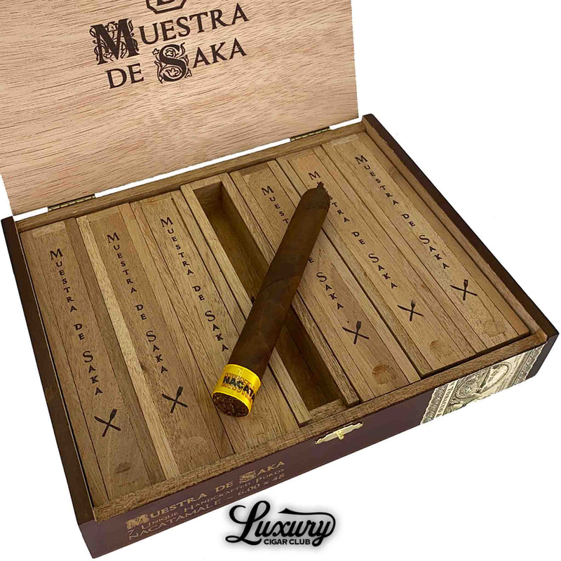 Close-up of the Dunbarton Tobacco & Trust Muestra de Saka Nacatamale cigar resting in its wooden case, showing detailed branding and craftsmanship, presented by Luxury Cigar Club.