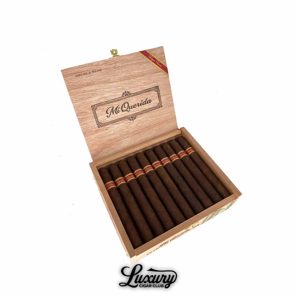 Open wooden box of Dunbarton Tobacco & Trust Mi Querida Triqui Traca No. 652 cigars, showcasing dark Maduro wrappers with red and gold bands. The lid features elegant script branding. Luxury Cigar Club logo below.