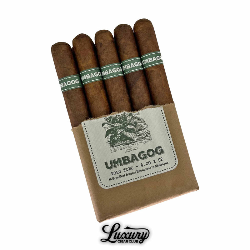 Open pack of Umbagog Toro Toro cigars showing five cigars with green bands, brown wrappers, and illustrated label, Luxury Cigar Club logo visible.