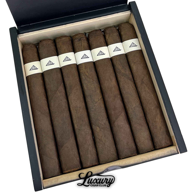 Close up view inside Fable Fourth Prime Sapta box showing neatly packed dark brown cigars with clean white bands, photographed for Luxury Cigar Club