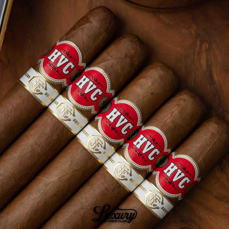Close-up of Fine Tobacco Club Ledger Series Vol. 1 HVC Robusto Extra cigars featuring rich brown wrappers and bold red-and-gold bands, presented by Luxury Cigar Club.