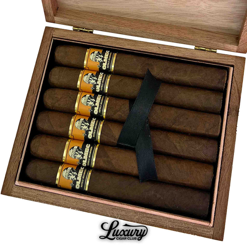 Close-up of Foundation Cigars Olmec Claro Toro box showcasing six premium handmade cigars with golden and black bands, neatly packed with a black ribbon, sold by Luxury Cigar Club
