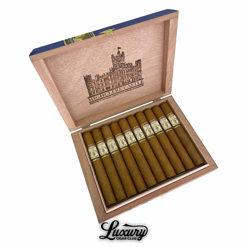 Open box of Foundation Highclere Castle Edwardian Toro cigars, featuring 10 light brown cigars arranged neatly in a wooden box. The cigars have elegant cream, gold, and red bands, and the lid displays a detailed illustration of Highclere Castle with branded text. “Luxury Cigar Club” logo appears below the box.