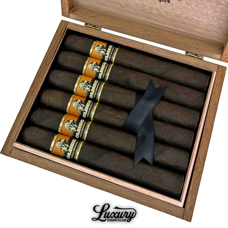 Close-up of Foundation Olmec Maduro Toro cigars in an open cedar box, highlighting the dark San Andrés wrappers, bold gold and black cigar bands, and elegant black ribbon, from Luxury Cigar Club.