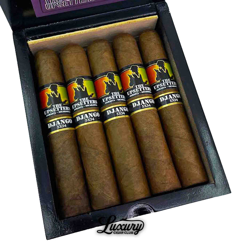 Close-up of Foundation The Upsetters Django cigars, revealing 7 neatly arranged medium-brown cigars with vibrant bands. Each band features a black silhouette with a red, orange, and yellow gradient background, labeled “THE UPSETTERS JAMAICA + NICARAGUA” and “DJANGO 5X54,” all housed in a sleek black box with “Luxury Cigar Club” branding below.