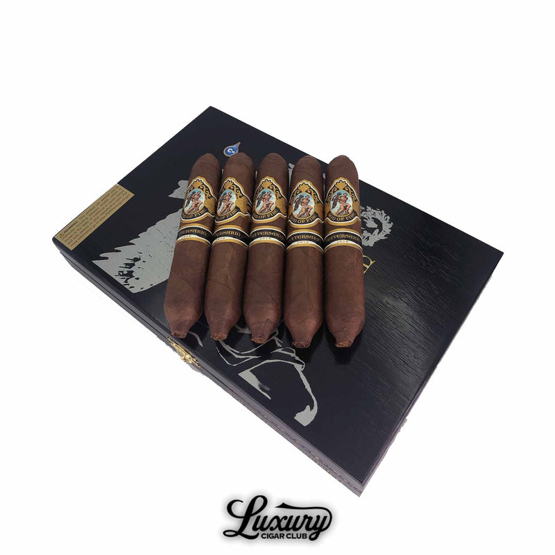 Five God of Fire Serie Aniversario Limited Edition 60 cigars from Luxury Cigar Club displayed on a sleek black presentation box with gold detailing, showcasing dark brown wrappers and ornate cigar bands.