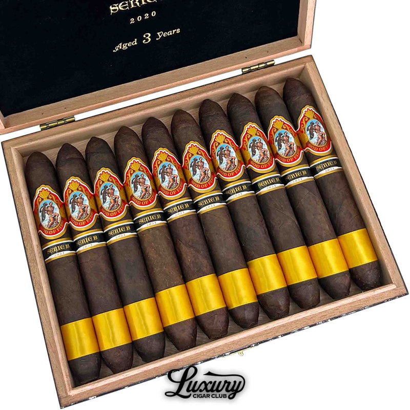 Close up of God of Fire Serie B Diademas 56 cigars displaying pointed diadema heads dark wrappers and gold foot bands inside the open presentation box for Luxury Cigar Club