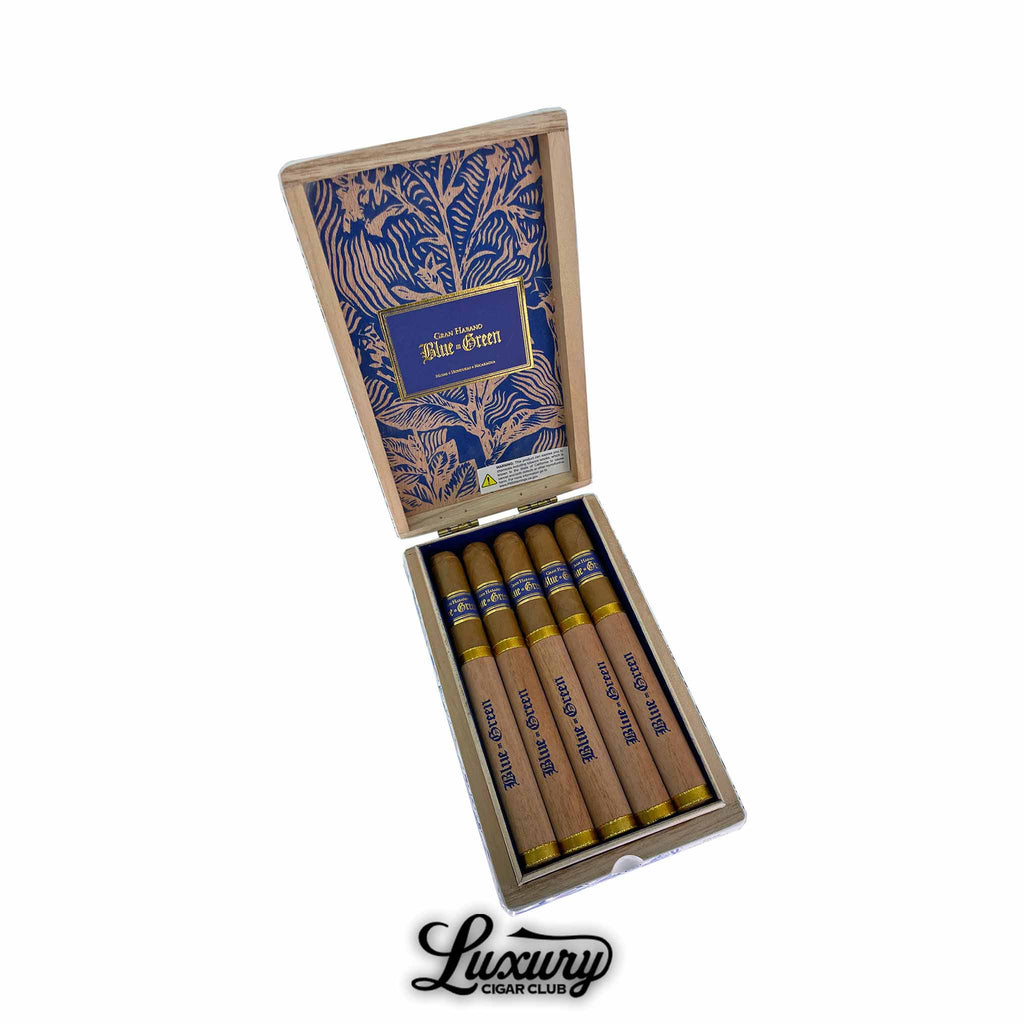 Open box of Gran Habano Blue in Green Churchill cigars with five cigars inside featuring wooden sleeves, gold accents, and blue detailing. Luxury Cigar Club logo below.