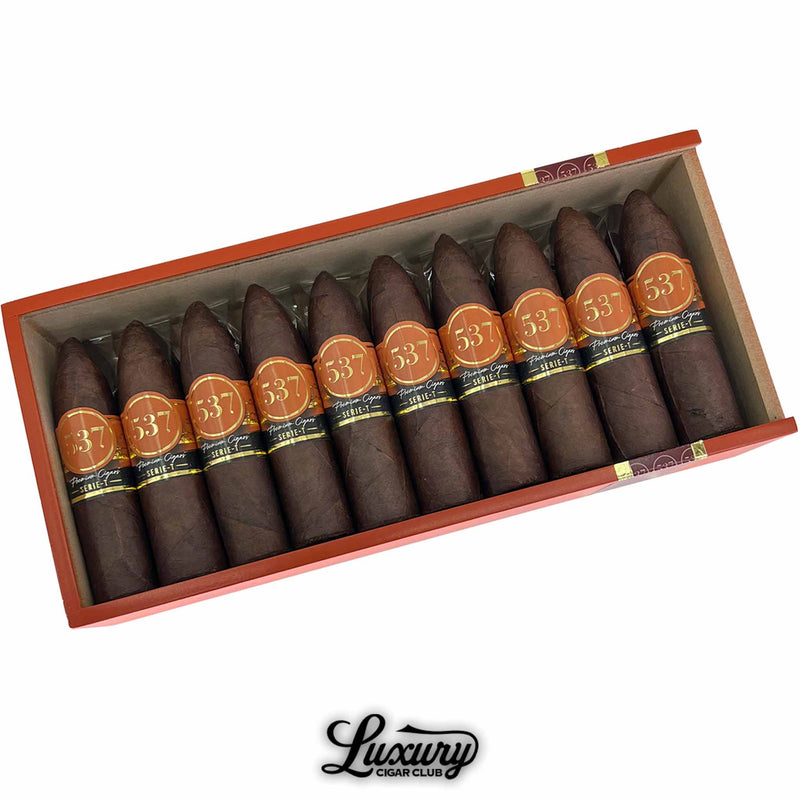 Close-up view of IGM 537 Rockets cigars in an open box, featuring pointed figurado shapes and bold orange bands, premium handcrafted cigars from Luxury Cigar Club.
