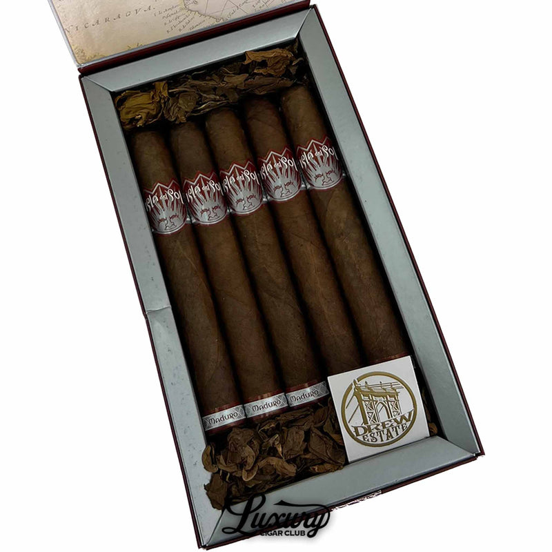 Box of Isla del Sol Maduro Toro cigars by Drew Estate, open with five cigars neatly arranged inside, surrounded by decorative tobacco leaf.