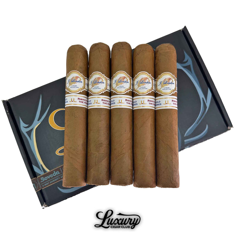 Close-up view of J London Gold Series Gordo Pre-Release cigars in a 5-pack bundle, featuring double bands with “Rising From the Ashes” branding, placed on a Boveda humidified box with Luxury Cigar Club logo—premium hand-rolled cigars for connoisseurs seeking rare, limited-edition releases.