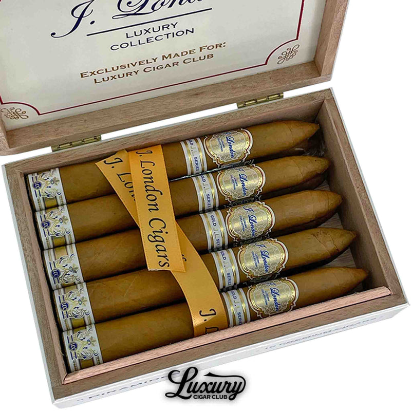 Close-up of J. London Gold Series LCC Exclusive Piramides cigars with gold bands and signature ribbon, emphasizing luxury craftsmanship and refined detail, featured by Luxury Cigar Club.