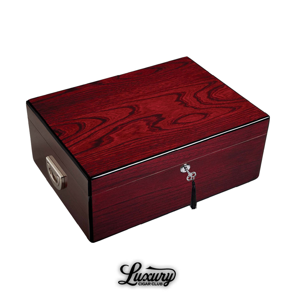 JC Newman Oxford Humidor in rich red wood grain finish with chrome lock and key detail, offering elegant cigar storage, featured by Luxury Cigar Club.