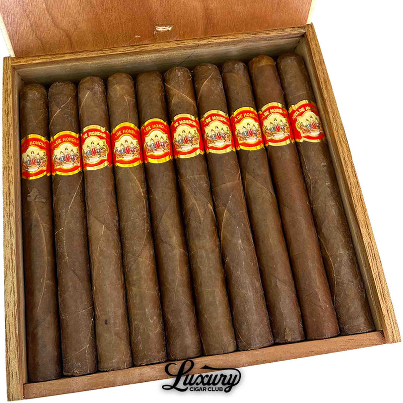 Close-up image of Joya de Honduras Churchill cigars from Luxury Cigar Club, emphasizing premium construction, oily brown wrapper, and ornate red and gold cigar bands.