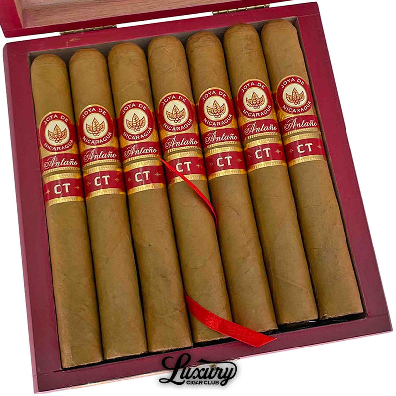 Close-up of Joya de Nicaragua Antaño Connecticut Toro cigars inside an open wooden box with red and gold detailing, highlighting the smooth Connecticut wrappers and red CT labels, presented by Luxury Cigar Club.