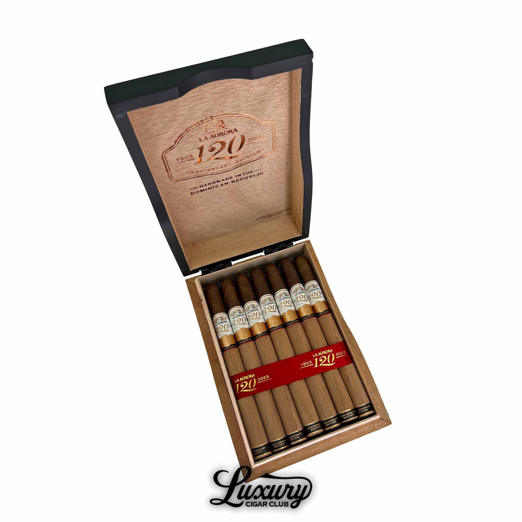 Open wooden box of La Aurora 120th Anniversary Edition Lancero cigars, handmade in the Dominican Republic, featuring elegant white and gold bands with red anniversary details.