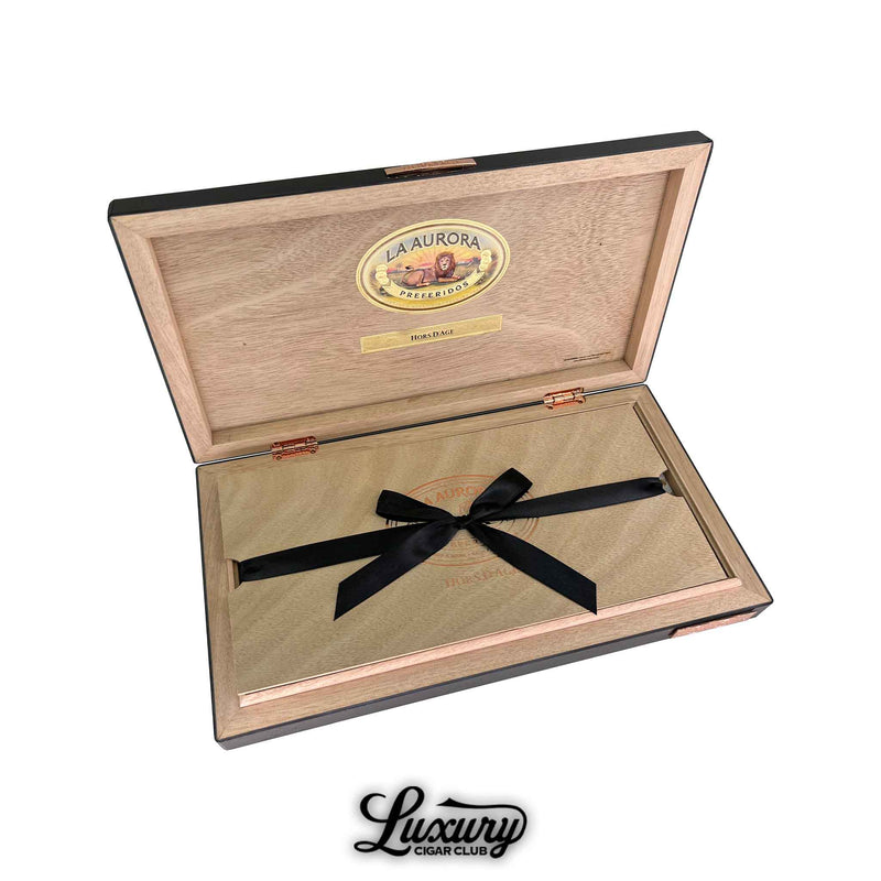 La Aurora Hors D’Age Limited Edition Toro box opened to reveal its premium wooden interior and ribbon presentation, emphasizing the brand’s heritage and refinement, featured by Luxury Cigar Club.