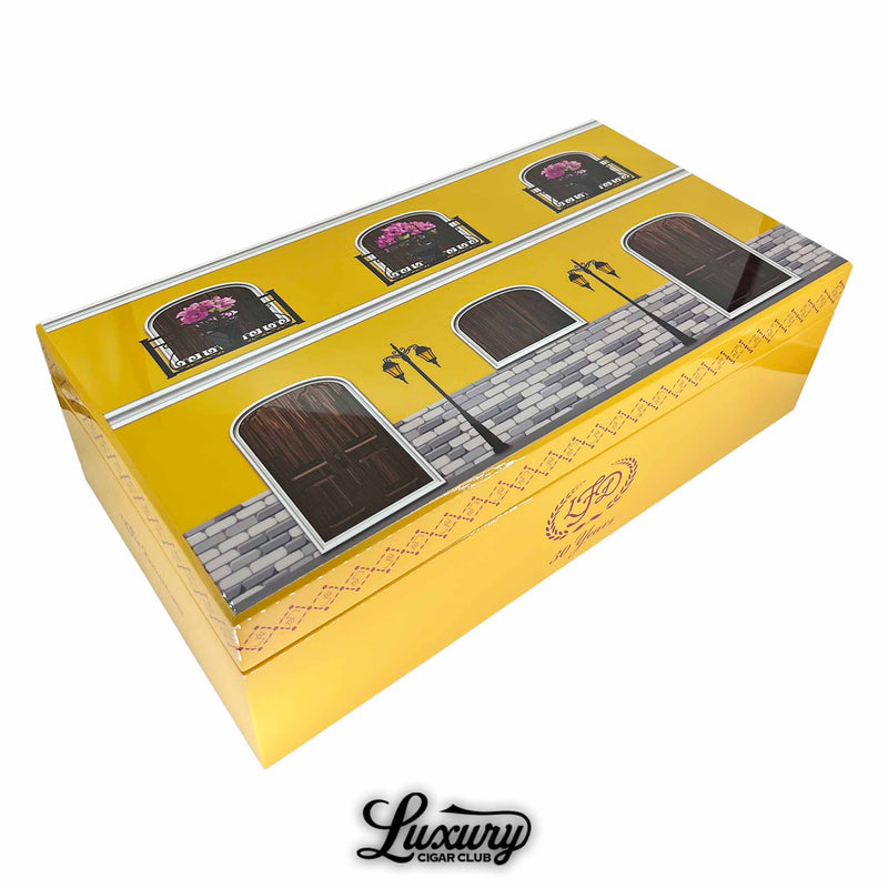 La Flor Dominicana 30th Anniversary Chisel yellow cigar box with artistic window and door design, shown with Luxury Cigar Club logo.