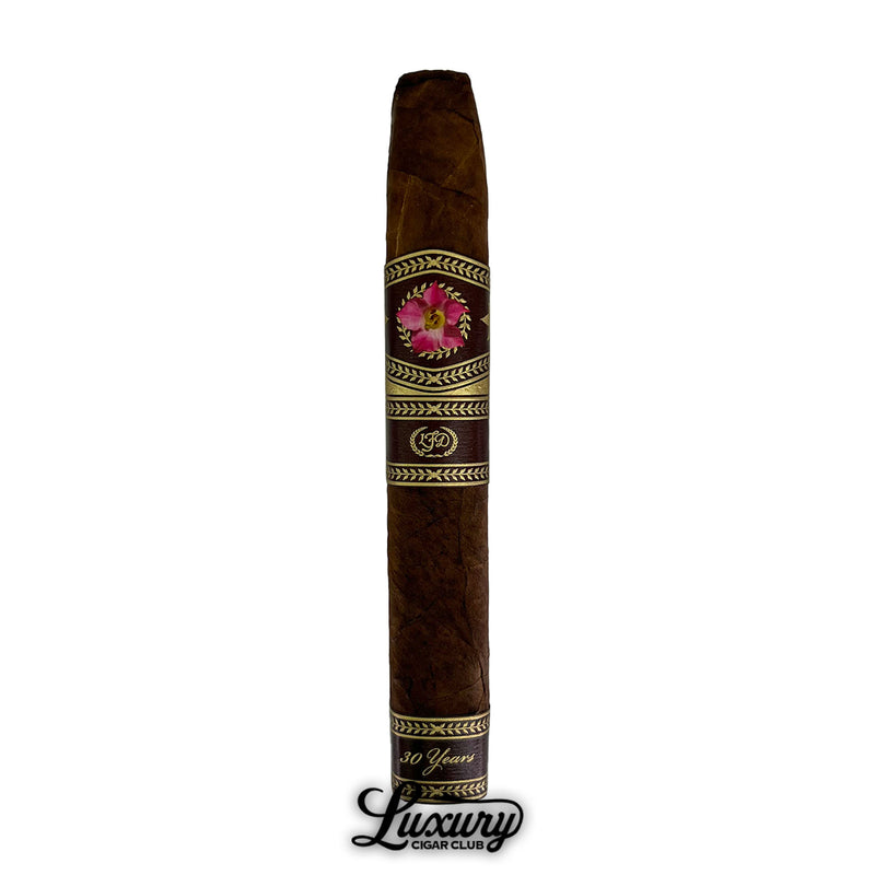 Single La Flor Dominicana 30th Anniversary Chisel cigar with brown wrapper and pink floral band, featured with Luxury Cigar Club logo.
