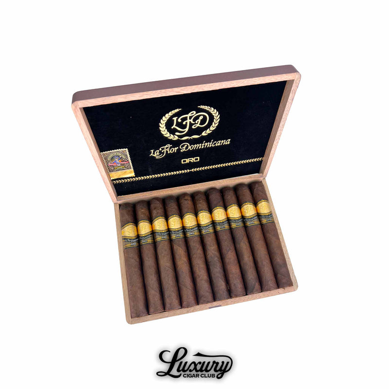 Luxury Cigar Club La Flor Dominicana Oro Maduro No 6 open cigar box showing neatly arranged dark maduro cigars with gold and black LFD Oro bands against a black and gold interior lid.