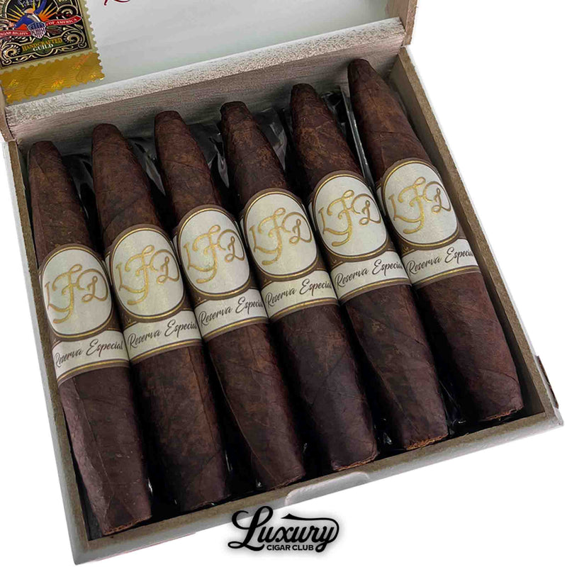 Close-up of La Flor Dominicana Reserva Especial Maduro El Jocko cigars highlighting the dark, oily wrappers and refined gold-and-cream band design, presented by Luxury Cigar Club.