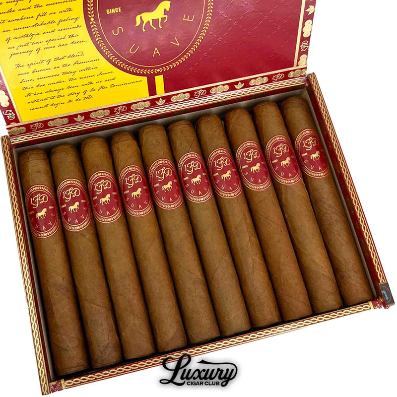 Close-up of La Flor Dominicana Suave Natural Maximo cigars arranged neatly inside their decorative red and gold box. The cigars’ golden-brown Connecticut wrappers and detailed LFD branding exude elegance and craftsmanship. Luxury Cigar Club.
