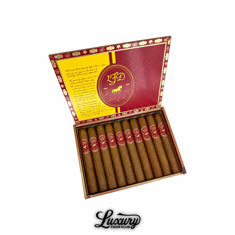 Open red and gold box of La Flor Dominicana Suave Natural Maximo cigars, featuring ten smooth Connecticut-wrapped cigars with red and gold LFD bands. The inside lid displays the LFD logo and brand story in elegant typography. Luxury Cigar Club.