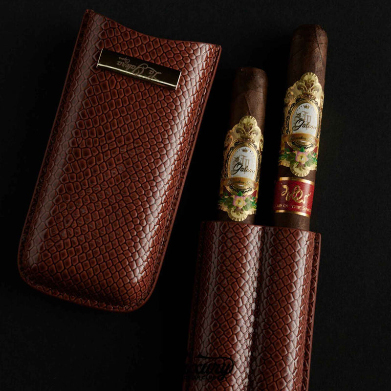 Close-up of La Galera Year of the Snake cigars in a detailed brown snakeskin-textured leather case, emphasizing the ornate gold cigar bands and premium presentation, featured by Luxury Cigar Club.