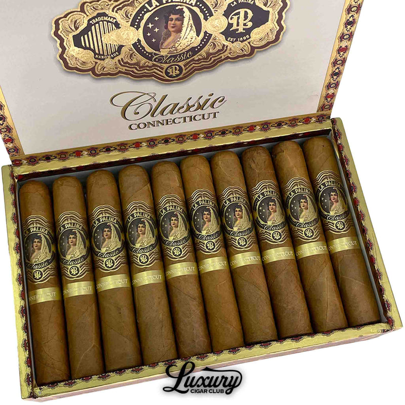 Close-up of La Palina Classic Connecticut Robusto cigars in a gold-accented box, displaying rich tan wrappers and detailed gold and black bands featuring the La Palina lady portrait logo. Luxury Cigar Club logo visible.
